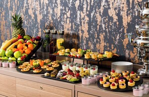 A buffet table with various food items and a decorative silver teapot.