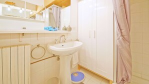 A bathroom with a sink, mirror, towel rack, and a shower curtain. - DolceVita Apartments N. 241 (Venice)