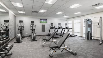 A gym with treadmills, elliptical machines, and weightlifting equipment.