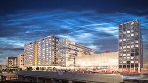 A modern hotel complex with multiple high-rise buildings, a prominent central building with a unique facade, and a well-lit street scene. - Original Sokos Hotel Tripla (Helsinki)