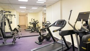 Een sportschool met loopbanden, elliptische trainers en gewichten.