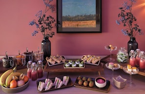 Een tafel gedekt met verschillende soorten eten, zoals belegde broodjes, gebak en fruit.