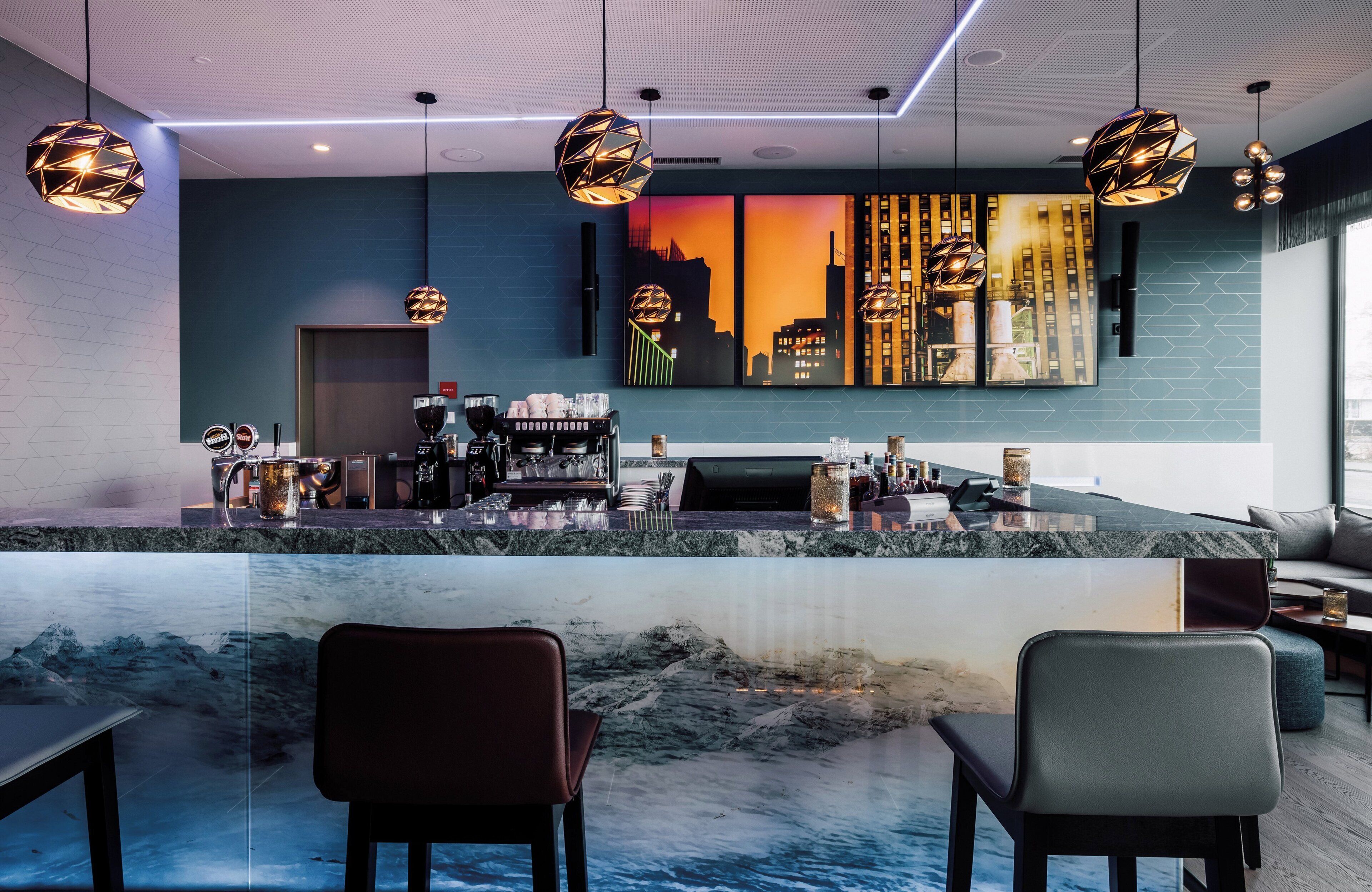Eine moderne Bar mit Stadtblick-Mural, Sitzgelegenheiten und einer Kaffeemaschine.