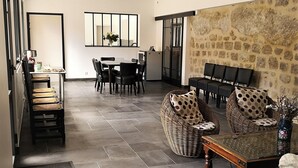 Un vaste espace de vie comprenant une table à manger, des chaises et un mur décoratif en pierre.