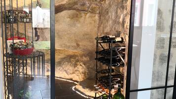 A wine cellar with a rustic stone wall, a wine rack, and a decorative metal cage.