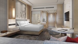 Una habitación de hotel moderna con una cama grande, un escritorio y un televisor.