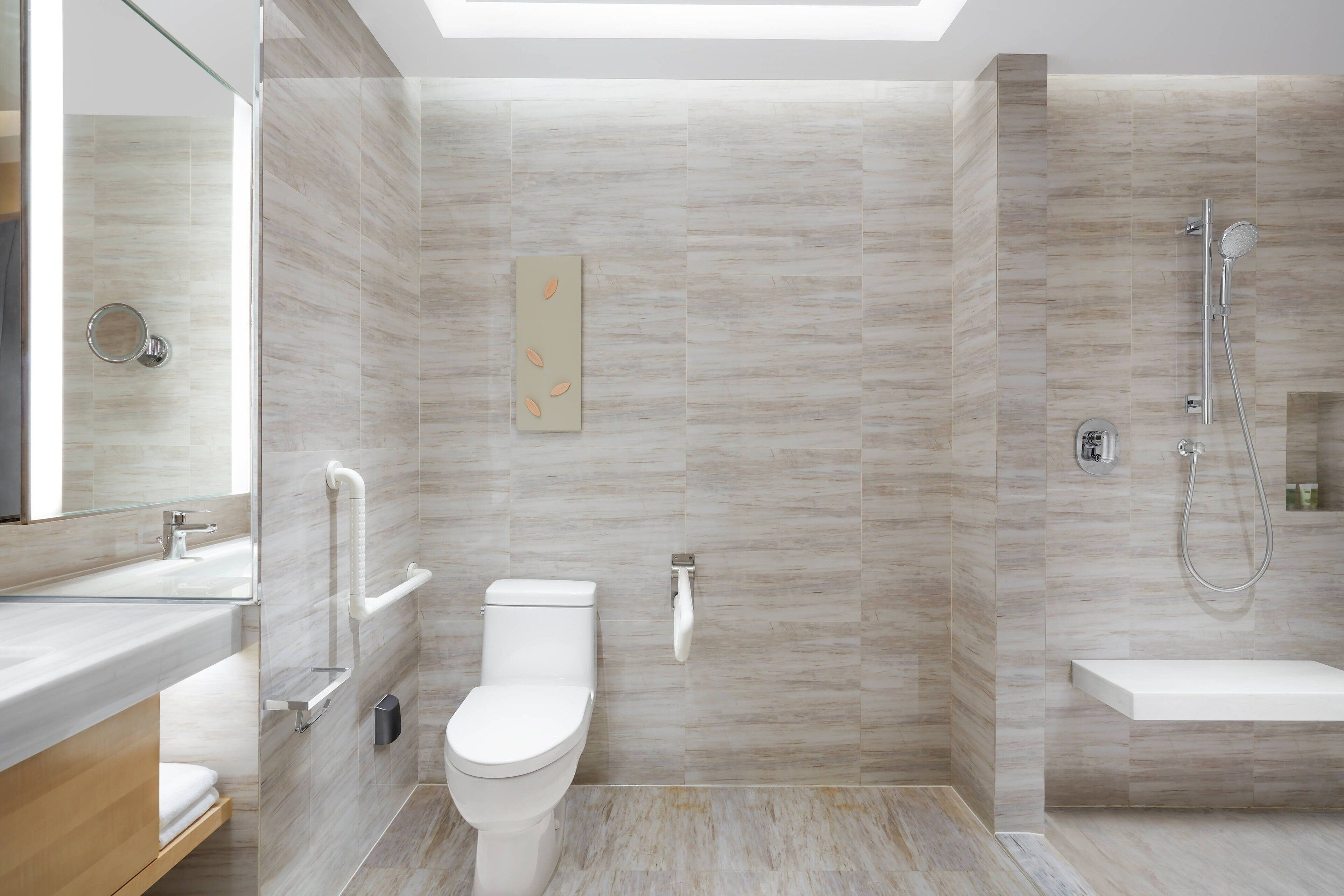 A modern bathroom with a glass shower enclosure, a toilet, and a sink.
