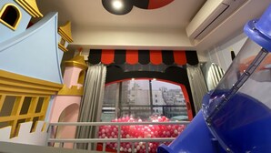 Een speelruimte voor kinderen met een glijbaan, een ballenbak en uitzicht op de stad.