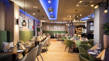 A restaurant with multiple dining tables, chairs, and a bar area.