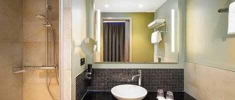 A modern bathroom with a shower, a sink, and a mirror.
