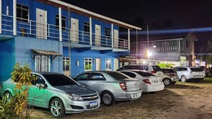 Una fila de coches aparcados frente a un edificio con varias ventanas y balcones.