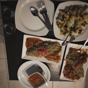 Una mesa de comedor con varios platos de comida, incluyendo platos de arroz y un tazón de salsa.