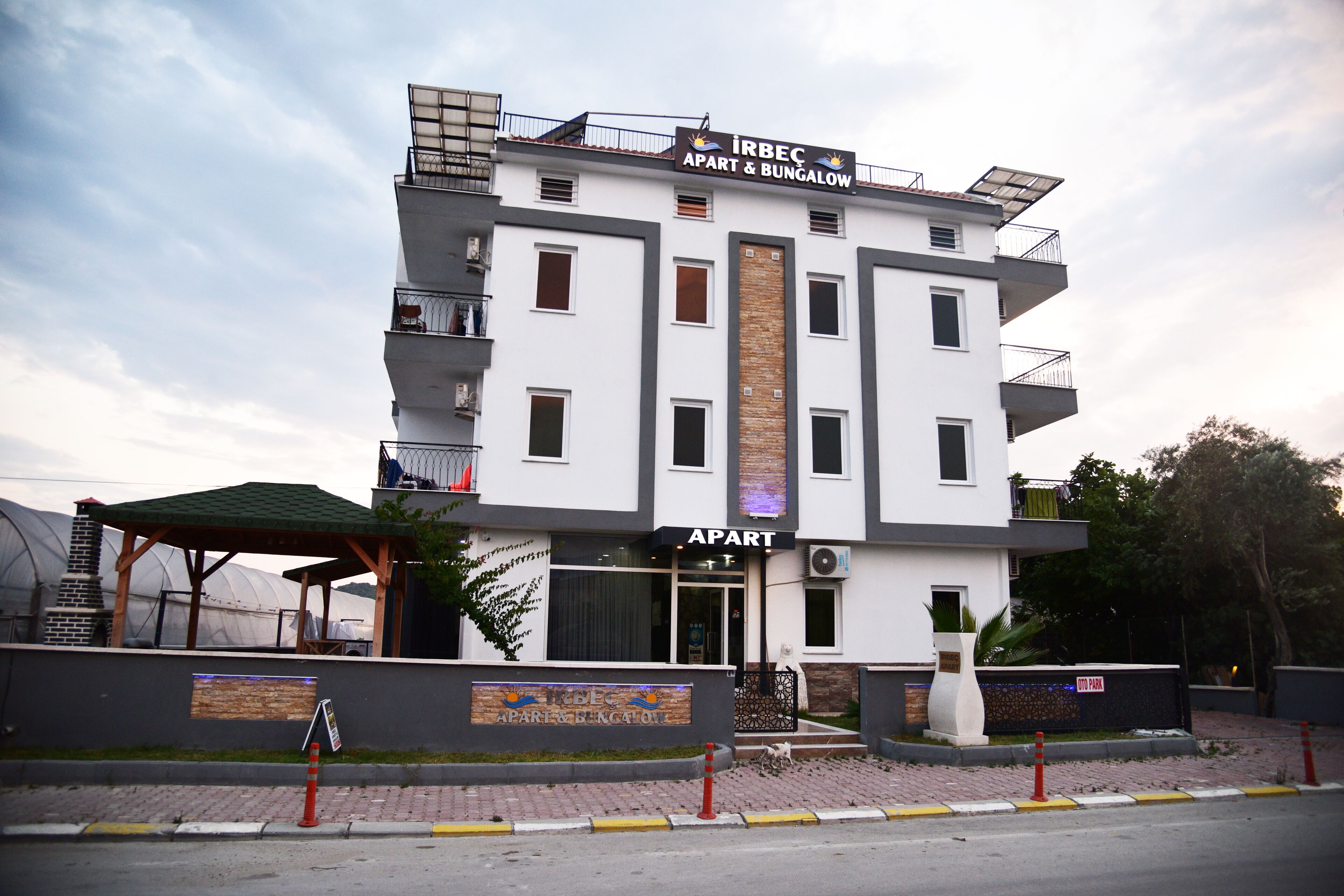 A multi-story building with a sign reading "IRBEC APART & BUNGALOW."