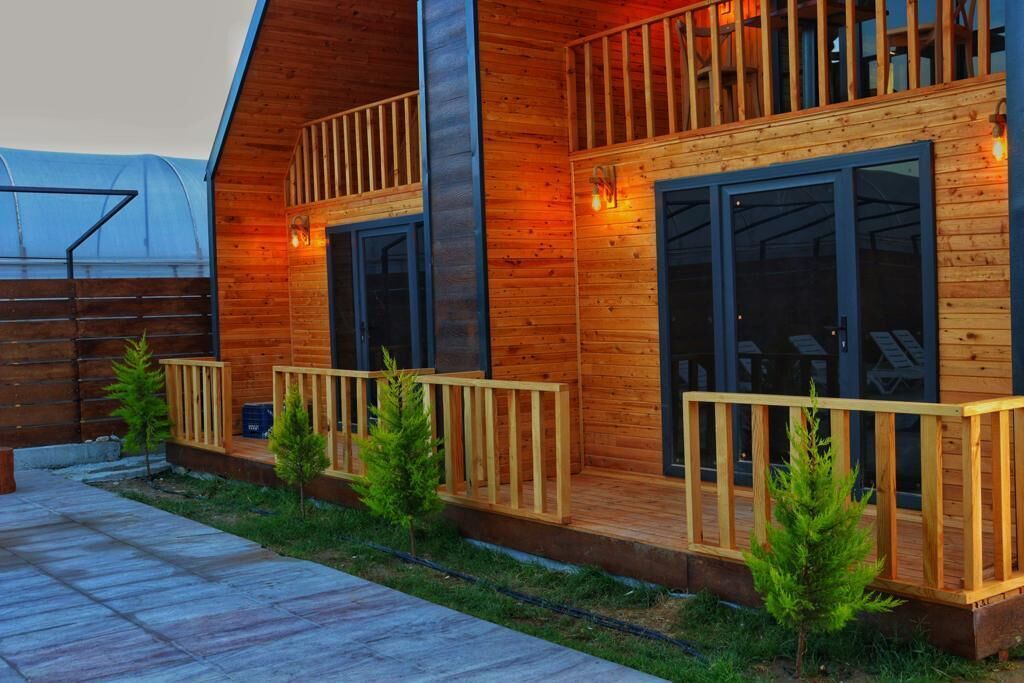 Eine Holzhütte mit Balkon und überdachter Terrasse.