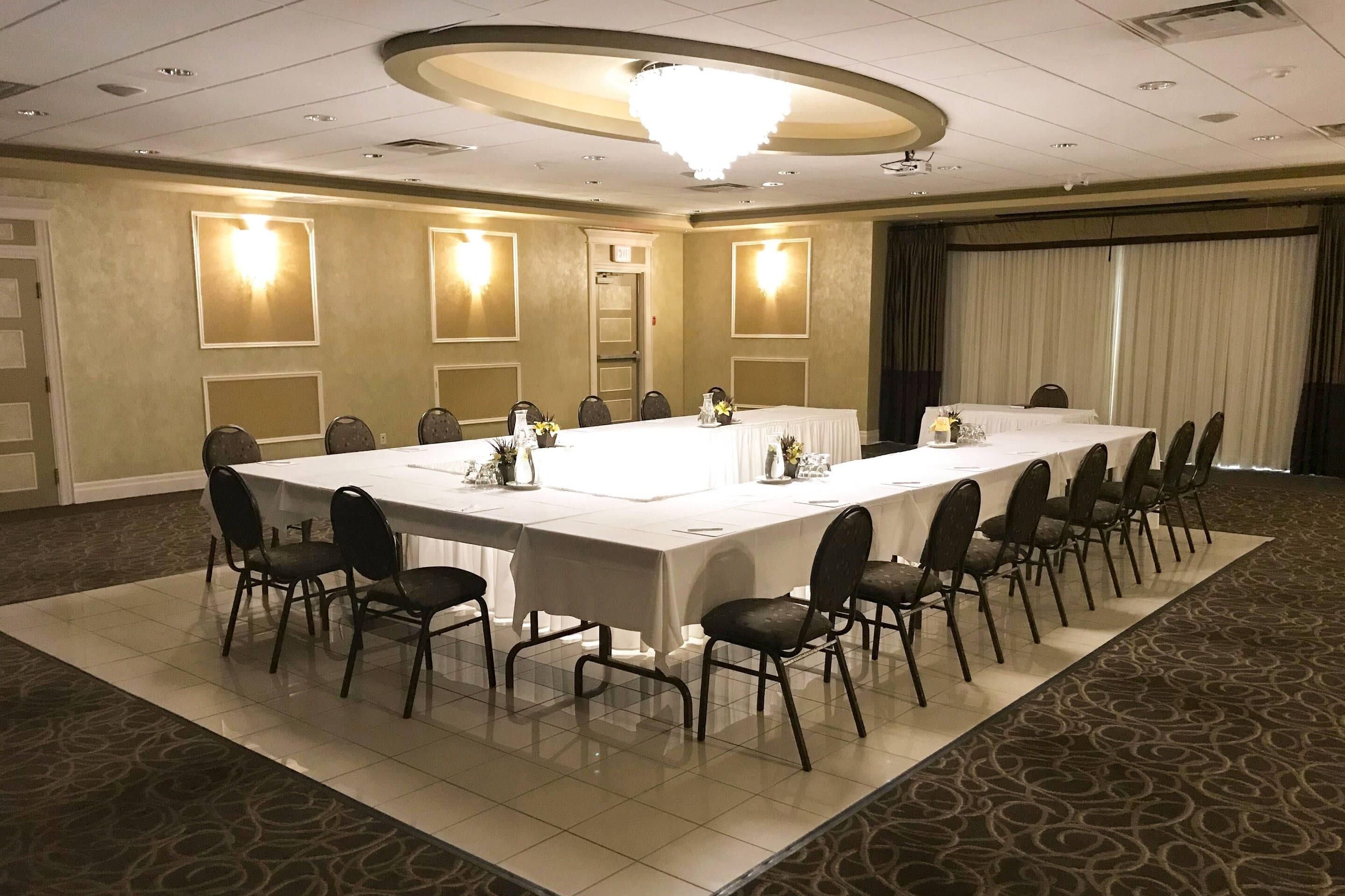 A conference room with a long table, chairs, and a chandelier.