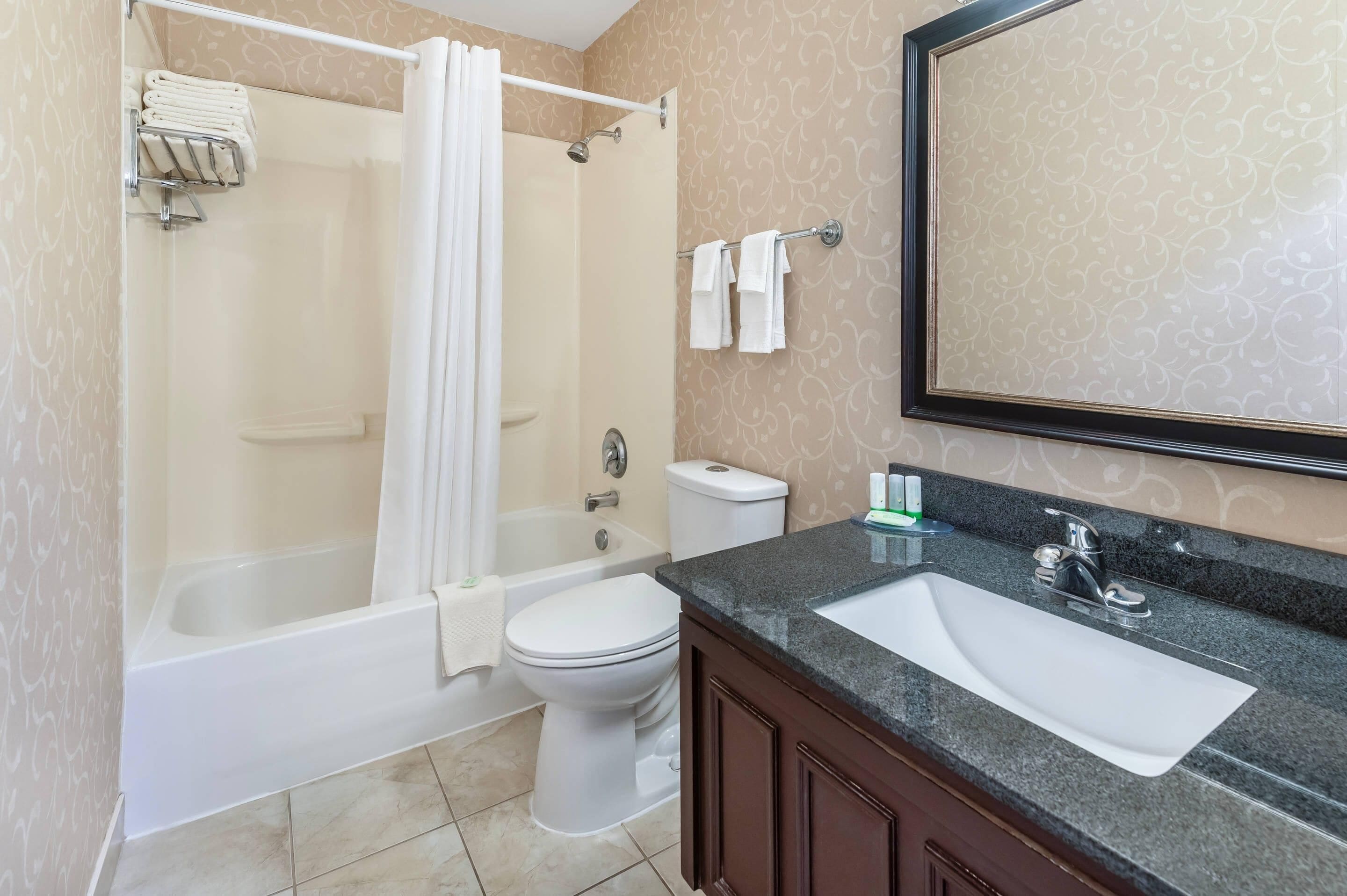 A bathroom with a bathtub, toilet, and sink.