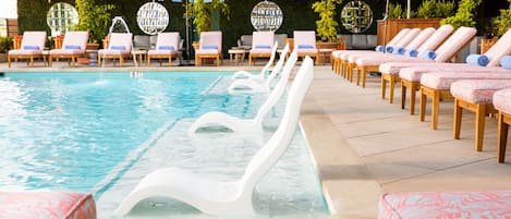 A poolside area with lounge chairs and umbrellas.