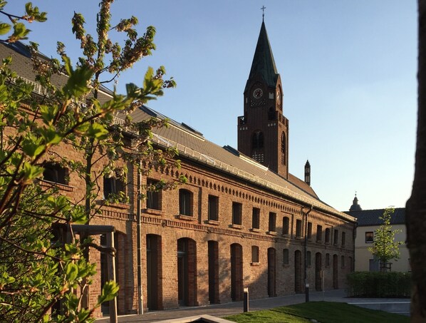 Un bâtiment historique doté d’un imposant clocher et de fenêtres en arc de cercle.