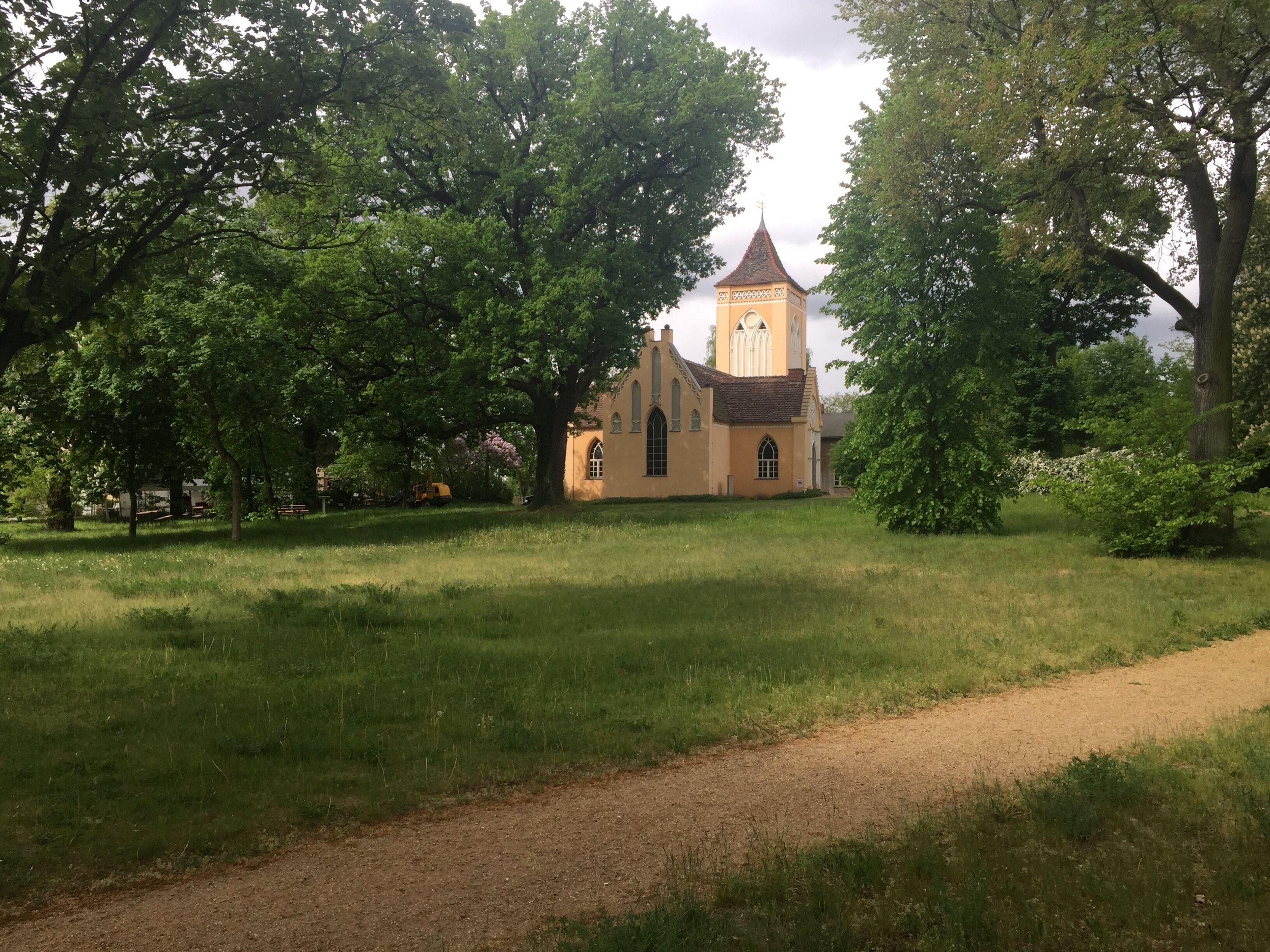 Eine Kirche mit einem hohen Turm und einem Weg, der dorthin führt.