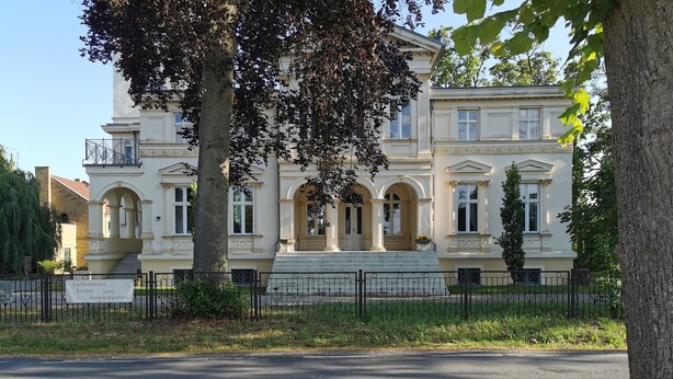 A classical building with a symmetrical facade, large windows, and a central entrance with steps. - Vacation home in expansive nature with Wi-Fi - to Berlin  / Potsdam 35 minutes (Paretz an der Havel)
