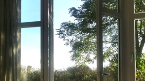 An open sliding glass door leading to an outdoor patio with a table and chairs. - Vacation home in expansive nature with Wi-Fi - to Berlin  / Potsdam 35 minutes (Paretz an der Havel)
