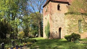 A church with a tall steeple, surrounded by trees and a cemetery. - Vacation home in expansive nature with Wi-Fi - to Berlin  / Potsdam 35 minutes (Paretz an der Havel)