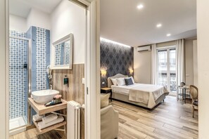 A modern bedroom with a large bed, bedside table, and a bathroom with a sink and shower. - Camera e Caffè Deluxe (Naples)