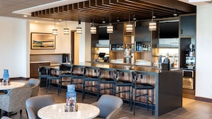 A modern bar area with seating, a counter with a menu, and a Starbucks logo. - Hyatt Place Flint / Grand Blanc (Flint)