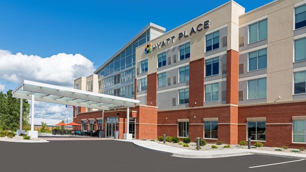 A modern hotel with a covered entrance, multiple floors, and a clear sky. - Hyatt Place Flint / Grand Blanc (Flint)