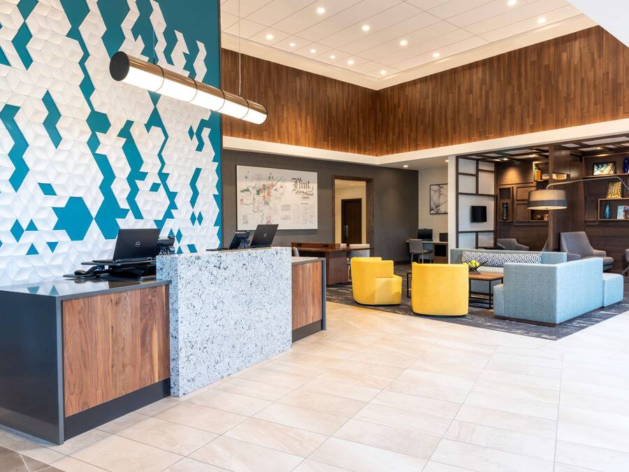 A modern lobby with a reception desk, seating area, and a large map on the wall.