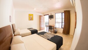 A hotel room with two beds, a desk, a chair, a TV, and a window with curtains. - Hotel Ricarlo (Iguala de la Independencia)