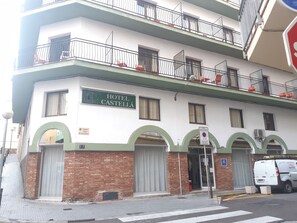 Un edificio de dos pisos con un letrero que dice "HOTEL CASTELLA".