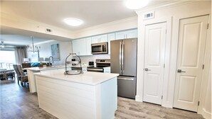 A modern kitchen with white cabinetry, stainless steel appliances, and a large island. - Summerlin Condominiums by Panhandle Getaways (Fort Walton Beach)