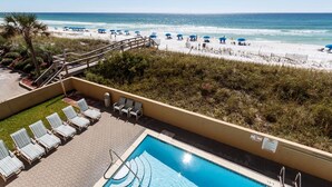 A pool area with lounge chairs, a view of the beach, and a no swimming sign. - Summerlin Condominiums by Panhandle Getaways (Fort Walton Beach)