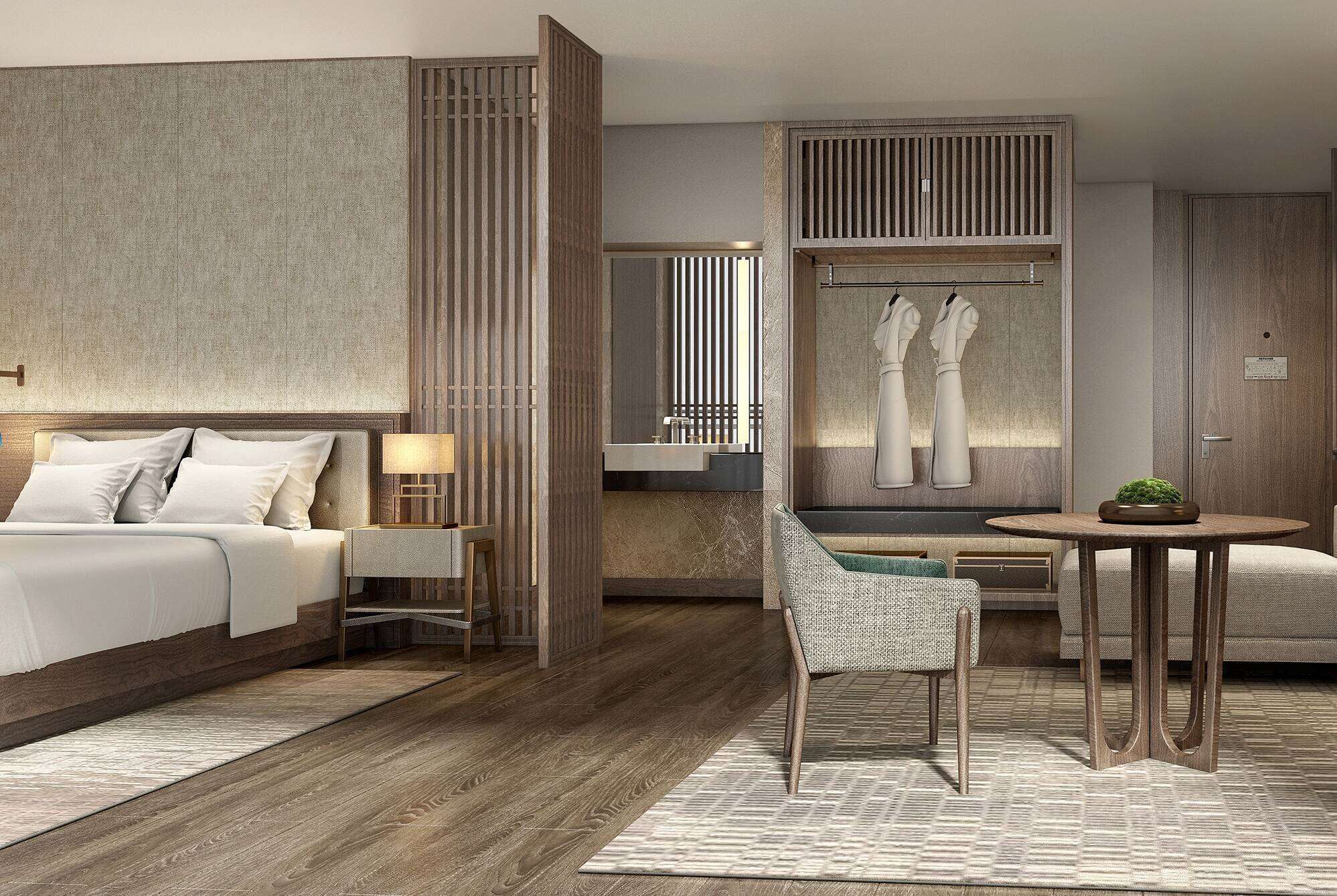 A modern hotel room with a bed, a sitting area with a table and chairs, a large mirror, and a decorative wall piece.