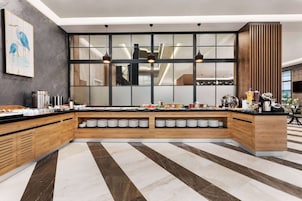 Una cocina moderna con una isla grande, estantes integrados y piso a rayas.