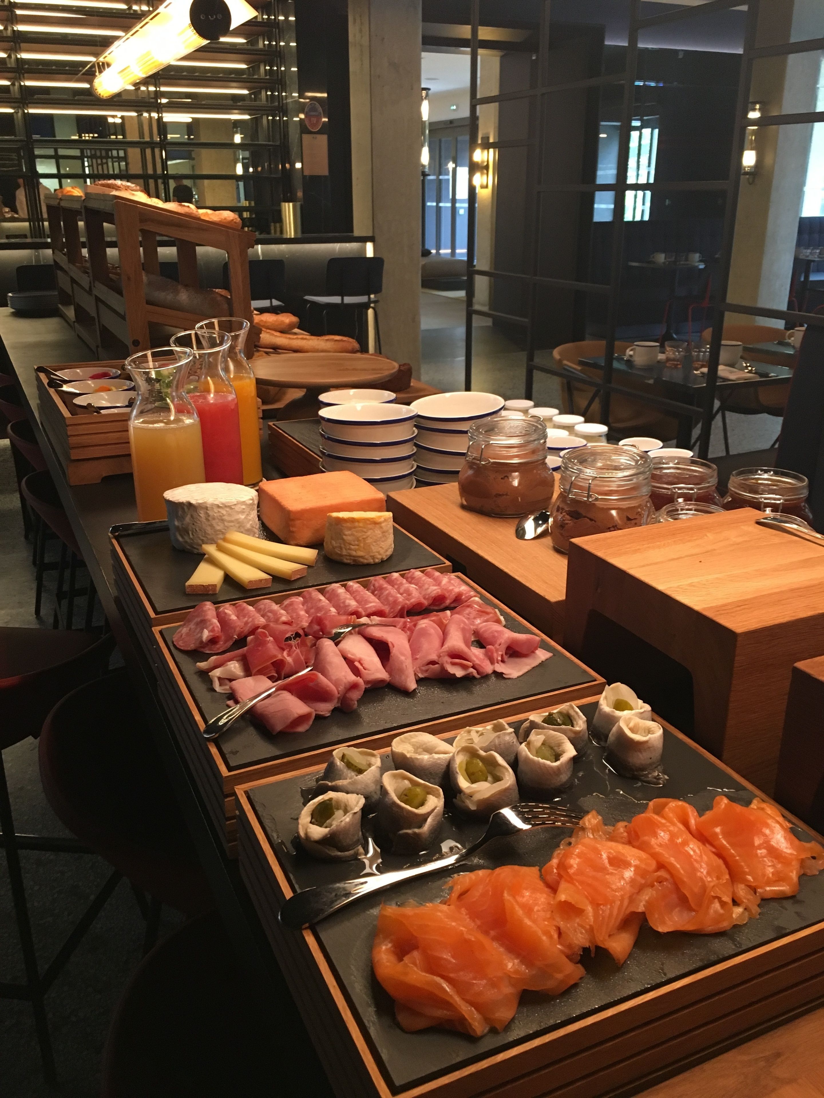 Een buffet met diverse gerechten, waaronder vleeswaren, kazen en gebak.