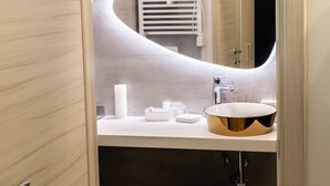 A compact bathroom with a wooden vanity, a white toilet, and a small stool. - B&B Bologna Fair Tower (Bologna)