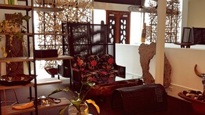 A modern interior with a wooden chair, a glass table with a plant, and a decorative wall. - CIRCA 1928 - Albury  (Albury)