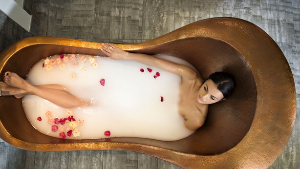 A person in a bathtub filled with water and rose petals. - CIRCA 1928 - Albury  (Albury)