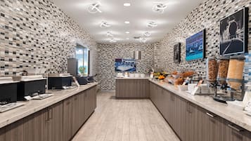 Una cocina moderna con un respaldo de azulejos a cuadros, una isla central y una zona de bufé con dispensadores de alimentos.