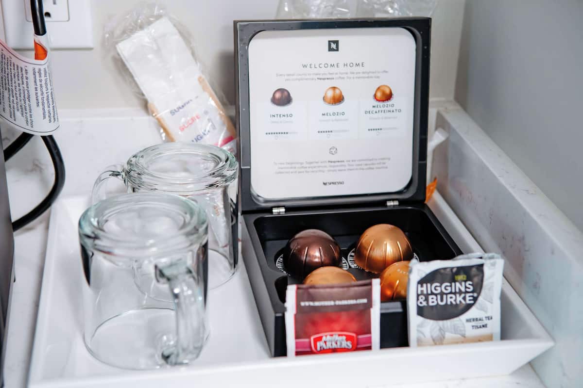 Eine Kaffeemaschine mit Pod-Halter, einer Glas-Kaffeekanne und einer Teebeutelpackung.