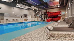 An indoor swimming pool with a red slide, lounge chairs, and a tiled floor. - Best Western Premier Winnipeg East (Winnipeg)