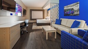 A modern hotel room with a wooden desk, a bed, a sofa, and a TV. - Best Western Premier Winnipeg East (Winnipeg)