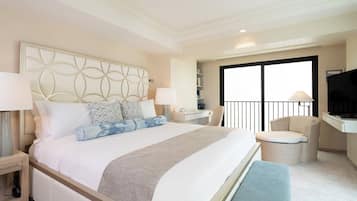 Habitación de hotel con una cama grande, mesitas de noche, una silla, televisión y un balcón con barandilla.