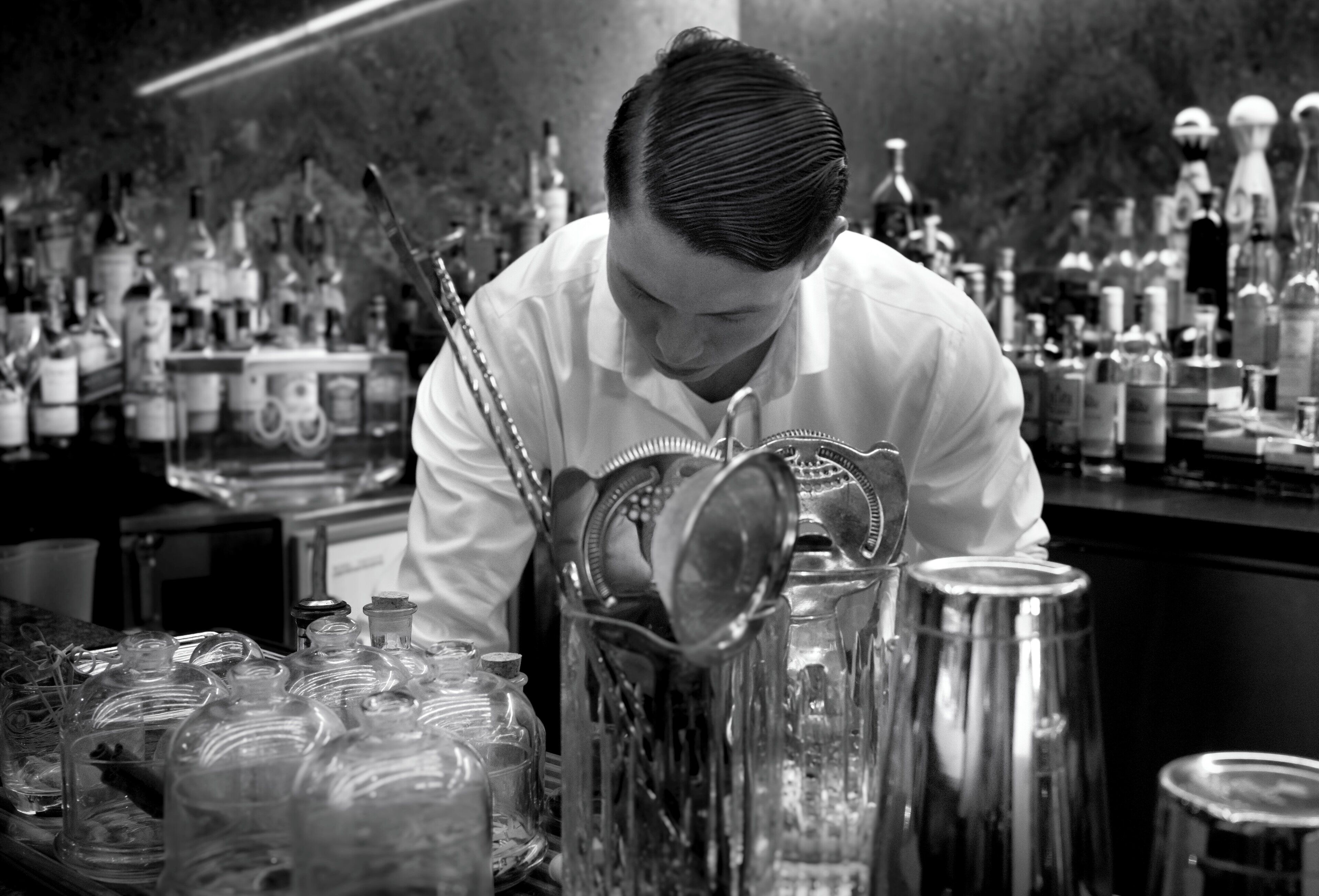 Un bar con un cantinero preparando bebidas.