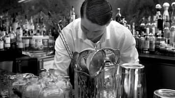 Un bar con un cantinero preparando bebidas.