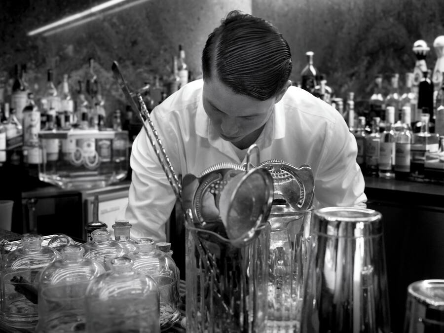 Un bar con un cantinero preparando bebidas.