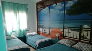 A room with two beds, a window with a view of the sea, and a lamp on the nightstand. - Habitacions Can Pau Guest House (Llanca)