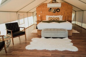 A tented room with a bed, a chair, a rug, and wooden walls. - Luxury Glamping Tent with Vineyard Views & Private Bathroom (Queen size) (San Antonio de las Minas)